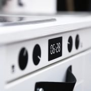 Close up of the oven knobs and the digital clock.